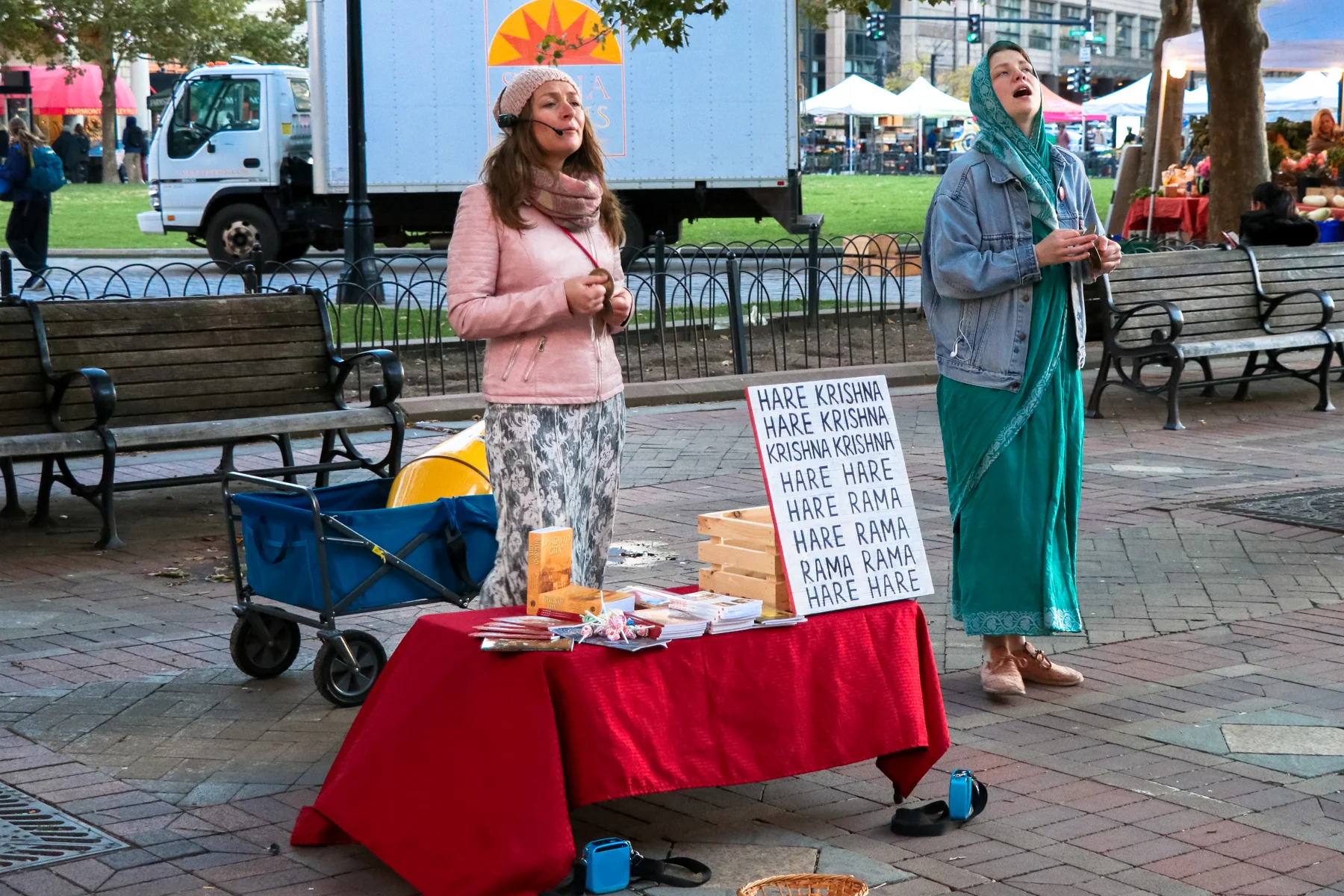 Dos devotas comparten el canto del mantra Hare Krishna al aire libre en Boston